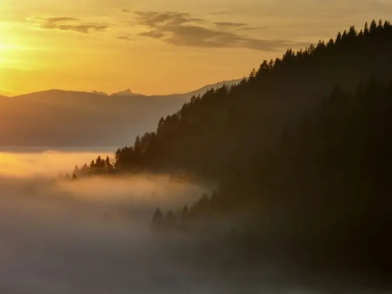 Die AKASHA Chronik - Das Feld Mit Nebel bedeckter Fuß von Berghängen im Sonnenuntergang - Symbol für die AKASHA Chronik als Feld und all den Erfahrungen und Weisheiten darin